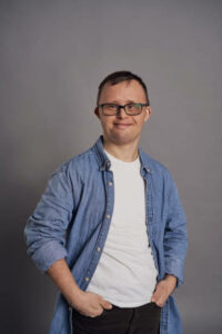 Portrait of man with down syndrome on gray background